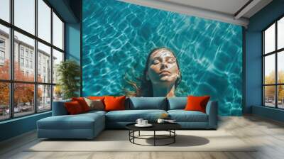 High angle view of woman relaxing in the swimming pool under clear blue water with closed eyes. Female face out of water, summer vacation concept.  Wall mural