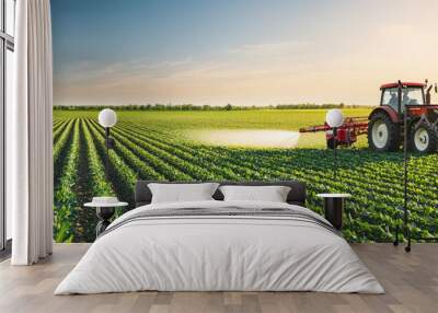 Tractor spraying pesticides on a corn field in summer, agricultural works at the beginning of the growing season Wall mural