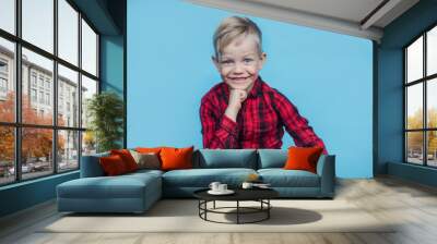 Handsome little boy with red shirt. Fashion. Studio portrait over blue background Wall mural