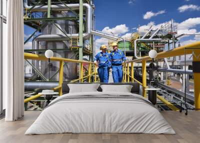 chemical industry plant - workers in work clothes in a refinery with pipes and machinery Wall mural