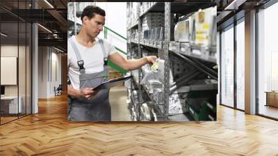 employees of a car repair shop in a warehouse for spare parts Wall mural