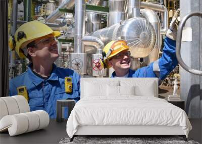 teamwork: group of industrial workers in a refinery - oil processing equipment and machinery Wall mural