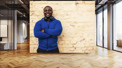 Portrait of sporty man standing in front of wall. Wall mural