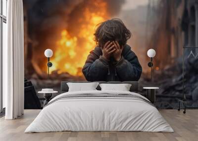 a little boy is crying covering his face with his hands against the backdrop of a war explosion Wall mural