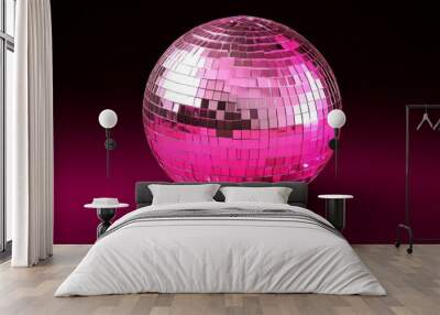 A vibrant pink and silver disco ball reflecting light in a dark setting with a soft glow, creating a playful atmosphere Wall mural