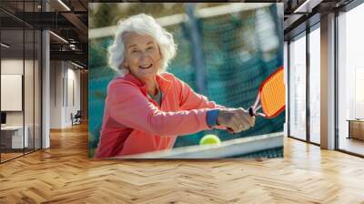 Senior woman playing pickleball, happy and active Wall mural