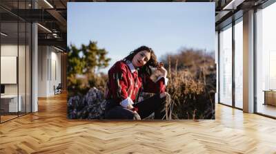 Beautiful young caucasian woman sitting on the forest on a sunny day Wall mural