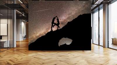 The copuple dancing on the clif in the starry night with brigt milky way galaxy. Silhouettes in the night. Wall mural