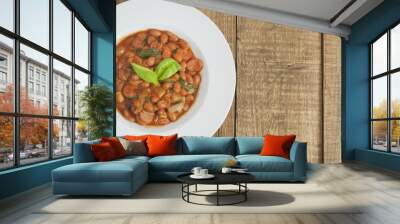 Cooked Red Beans in Tomato Sauce with Spinach and Onion, white Round Plate, Wooden Background, Top view, Copy space. Wall mural