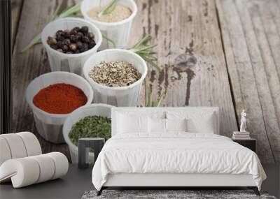 Various spices on wooden rustic background: rosemary, paprika, black pepper. Top view. Copy space. Wall mural