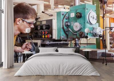 A trainee in the metalworking industry works on a milling machine Wall mural