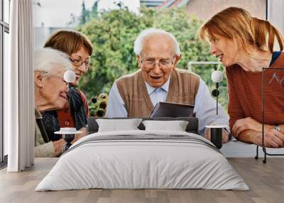 Elderly couple and daughters, looking at laptop screen Wall mural