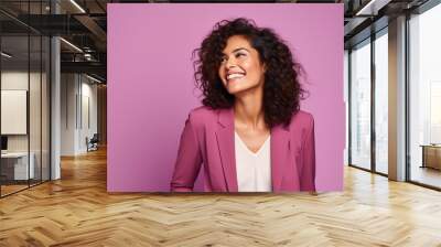 Cheerful young business woman looking away and smiling while standing against purple background Wall mural