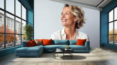 Portrait of a beautiful mature businesswoman laughing against a grey background Wall mural