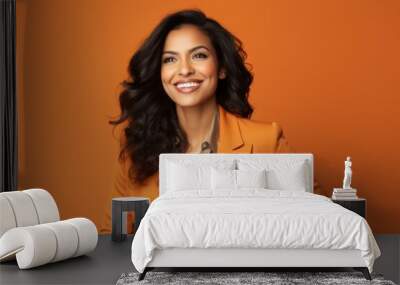 Portrait of happy smiling young businesswoman in orange suit, over orange background Wall mural