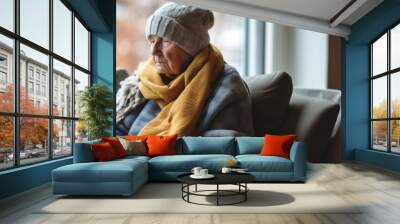 A senior person wrapped up in a scarf and hat during winter. Cost of living Heating gas bill Wall mural