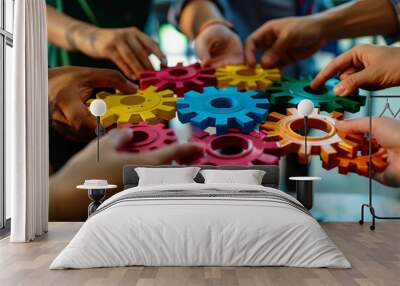 Close up of a team of business people holding colorful gears in their hands working together Wall mural