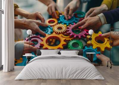 Close up of a team of business people holding colorful gears in their hands working together Wall mural