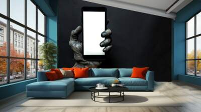 Creepy halloween monster zombie hand holding a mobile phone with a blank screen Wall mural