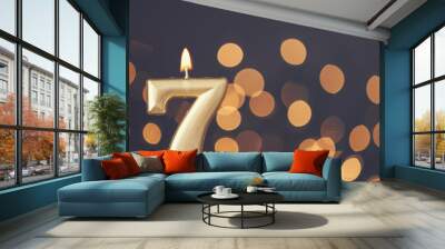 Gold number 7 celebration candle against blurred light background Wall mural