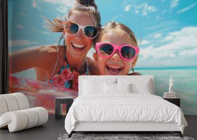 Mother and daughter in sunglasses with inflatable ring at beach, having fun on summer vacation Wall mural