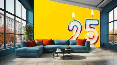 number 25 birthday celebration candle against a bright yellow background Wall mural