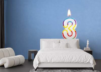 Number 3 birthday candle in a cupcake against a blue background Wall mural