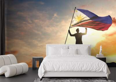 Philippines flag being waved by a man celebrating success at the top of a mountain. 3D Rendering Wall mural