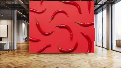 Red chili peppers arranged on a bright red background Wall mural