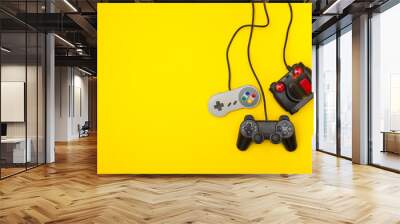 Retro computer gaming controllers on a bright yellow background Wall mural