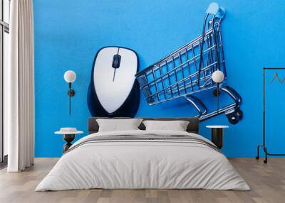 Shopping cart on a blue background with computer mouse Wall mural