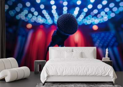 An evocative image of a microphone on an empty stage, bathed in vibrant stage lights with a backdrop of red curtains. Represents performance, speech, and anticipation in an entertainment setting. Wall mural