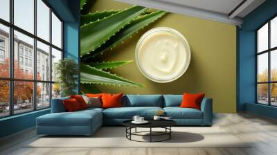 Beautiful cream bottle with beauty products aloe leaves on green background. Natural organic skin care. Wall mural