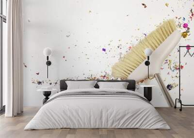 Close-up of broom on the white background.Sweeping confetti after a party or celebration. Colorful confetti lying on the white background or on the floor. Sweeping trash after party with bristle broom Wall mural