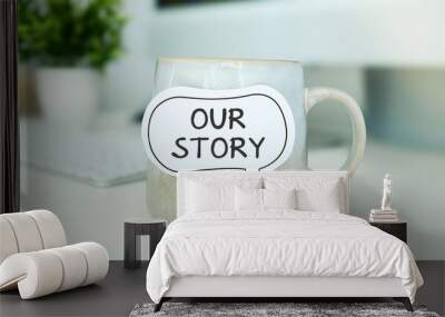 Coffee mug with text Our Story in workplace background. Wall mural