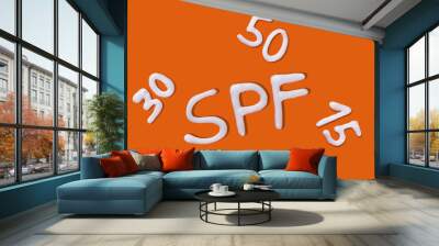 SPF cream. Sunscreen cream on orange background. Creative idea of suntan lotion cream. Sun ultraviolet protection concept. Wall mural