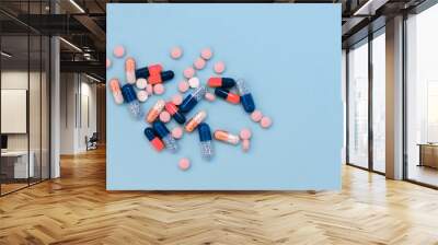 Heap of colorful pills, tablets, capsules on blue background. Drug prescription for treatment medication health care concept wth copy space. Wall mural