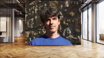 Portrait of an Italian man with dark hair against a medieval wall Wall mural