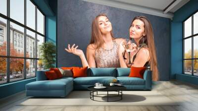 Beautiful girls in dresses celebrate a new year party enjoy champagne.Young women laughing, dansing, having fun and enjoy a holiday on a blue background.Concept of a holiday.New Year, birthday, party Wall mural