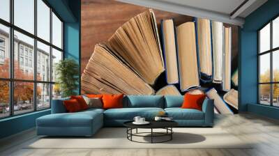 Old and well used hardback books or text books in a book shop or library. Many Books Piles. Hardback books on wooden table top view. Back to school background with copy space. Wall mural