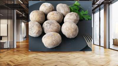 Potatoes with a sprig of parsley on a black plate. A traditional Canarian dish is papas arrugadas. Vegetables are boiled in water with a lot of salt. Wall mural