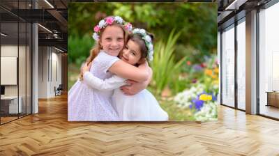 Two happy multiracial children with white dress playing outdoors. Kids having fun in spring park. Friends hugging on nature background. Side view portrait. Wall mural