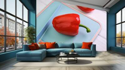 sweet red peppers and a knife on a cutting board, on a white wooden background Wall mural