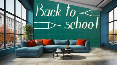 White chalk writing on a green chalkboard - back to school close-up and copy space. Wall mural