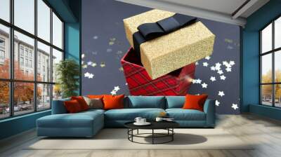 Christmas pattern gift box red and gold on a dark  background, decorated with a textured bow, creating a romantic atmosphere. Typically used for birthday, anniversary presents, gift cards, post cards. Wall mural