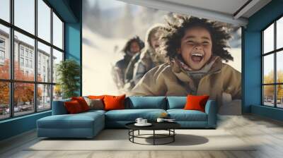 Funny little dark-skinned child rides on a sleigh in the snow. Active sports games in winter. Happy winter holidays concept. Wall mural