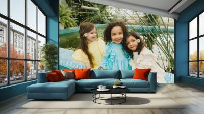 Three little girls in the garden. children of different nationalities. two swarthy babies and one white girl. Wall mural