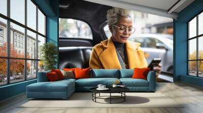 Candid shot of a smiling middle-aged African American businesswoman using a smartphone in a taxi cab, showcasing, generative ai Wall mural