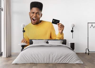 Afro american man holding credit card screaming proud and celebrating victory standing over isolated white background Wall mural