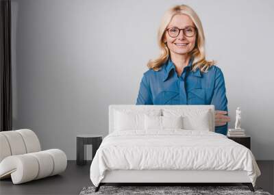 Confident beautiful mature woman teacher with arms crossed isolated over grey background Wall mural